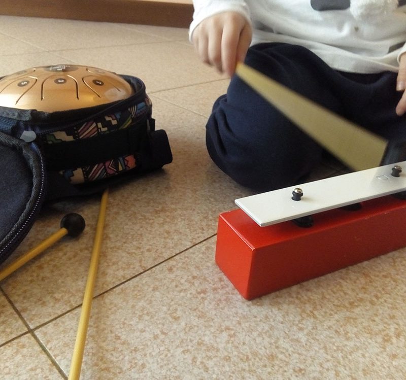 un bambino mentre suona lo xilofono sul pavimento