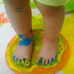 i piedi di un bambino sporchi di tempera al nido in famiglia